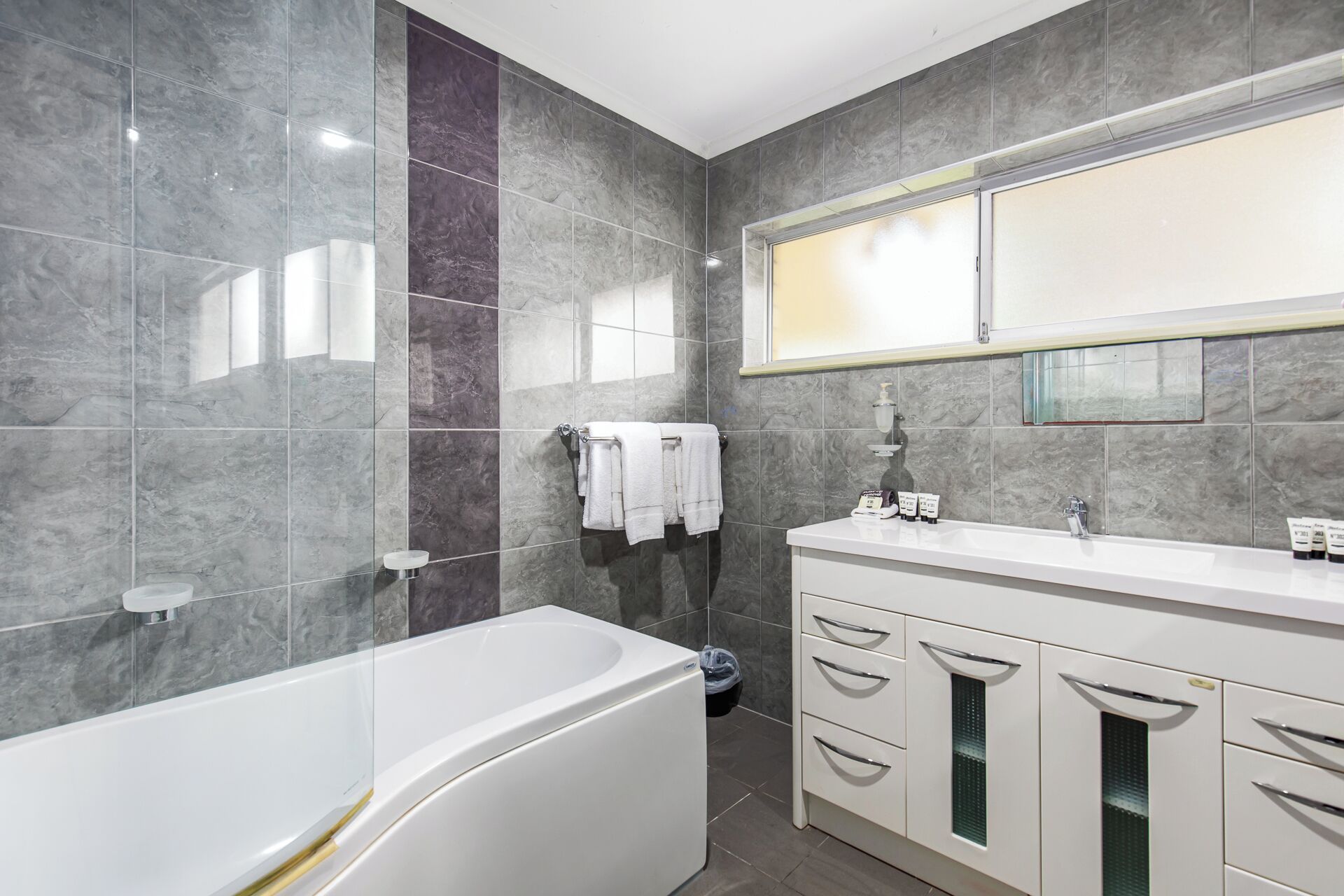 Un baño moderno con una bañera independiente, un tocador con espejo y una zona de ducha.
