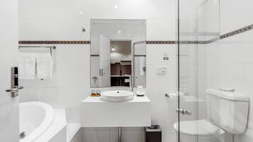 A modern bathroom with a white sink, mirror, and bathtub.