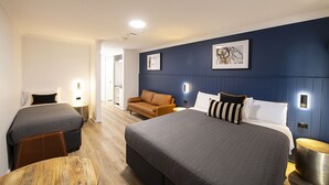 A hotel room with two beds, a sofa, and a dining table. - Southend Hotel (Maroubra)