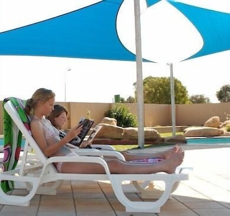 Una piscina al aire libre, sillones reclinables de piscina. Horsham Holiday Park (formerly Wimmera Lakes Caravan Park)