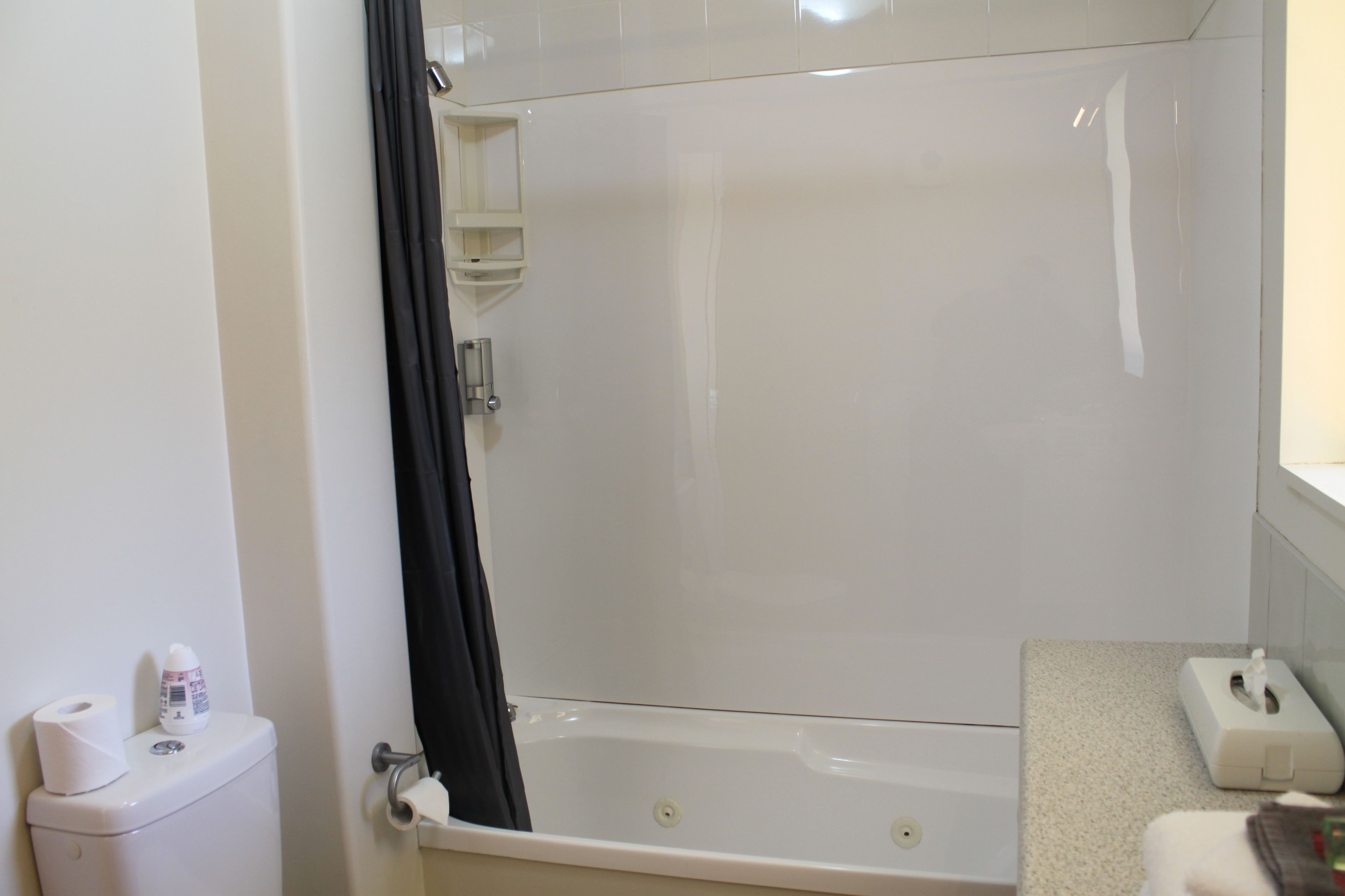 Ein Badezimmer mit Badewanne, Toilette und Handtuchhalter.