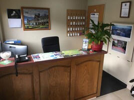 Un mostrador de recepción con un mapa, un teléfono y una planta.