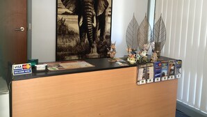 Ein Empfangsschalter mit einem großen Elefantenbild, einer Tür und einem Fenster mit Jalousien.