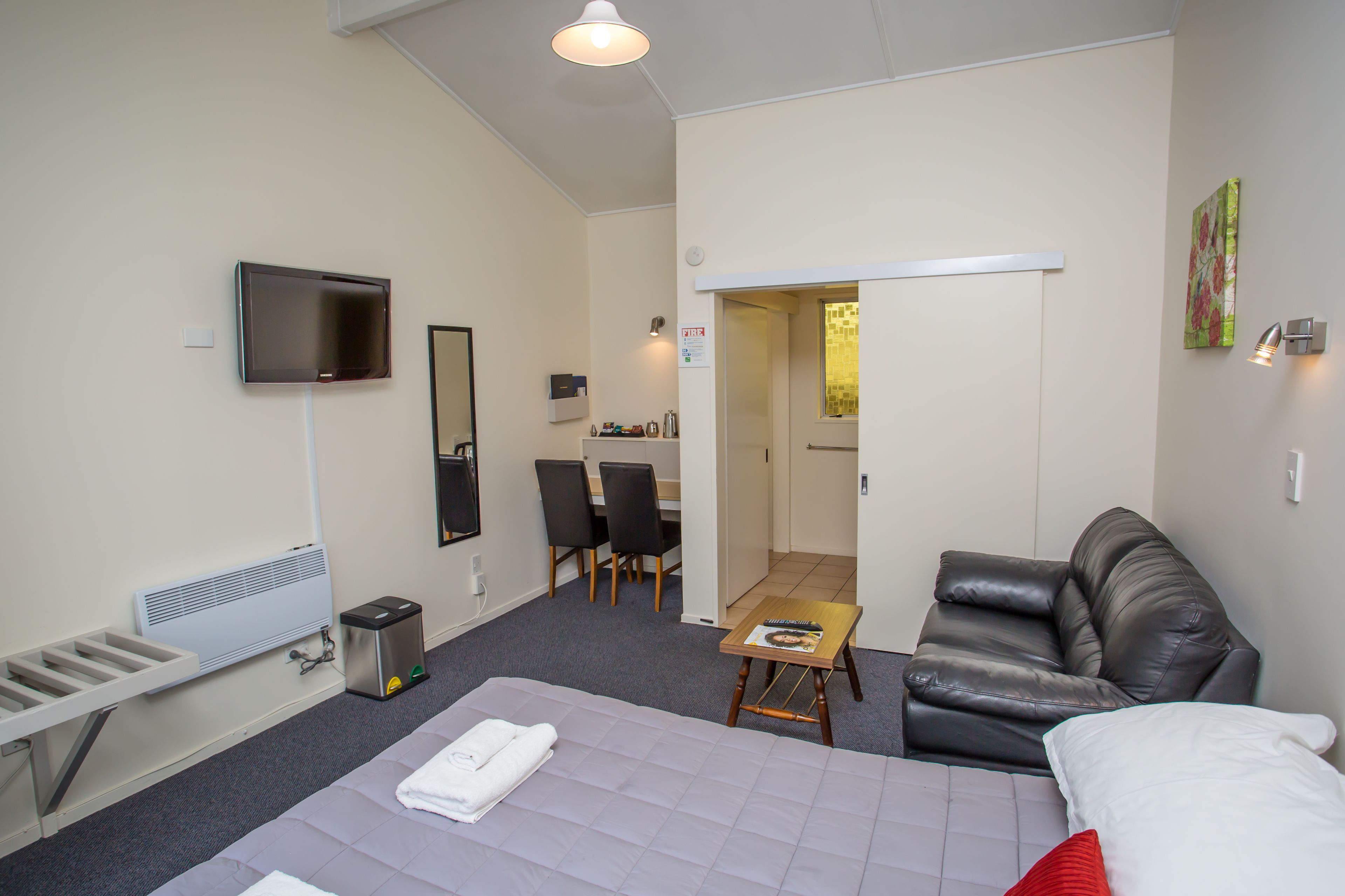 Una habitación de hotel con cama, televisión, escritorio y silla.