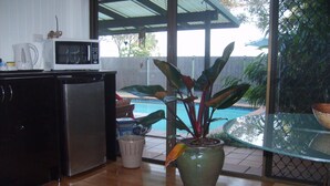A kitchen with a refrigerator, microwave, and a potted plant. - Tantarra Guest House (Warners Bay)