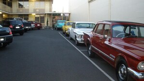 Un estacionamiento con varios coches clásicos aparcados en filas.