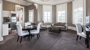 Amplia sala de estar con mesa de comedor, sillas, sofá y una araña.