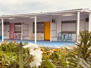 A building with a covered porch, multiple doors, and outdoor seating. - Stonez Boutique Accommodation (Clunes)
