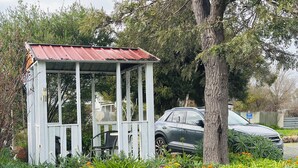 A gazebo with a metal roof and white walls, surrounded by a garden with various plants and flowers. - Stonez Boutique Accommodation (Clunes)
