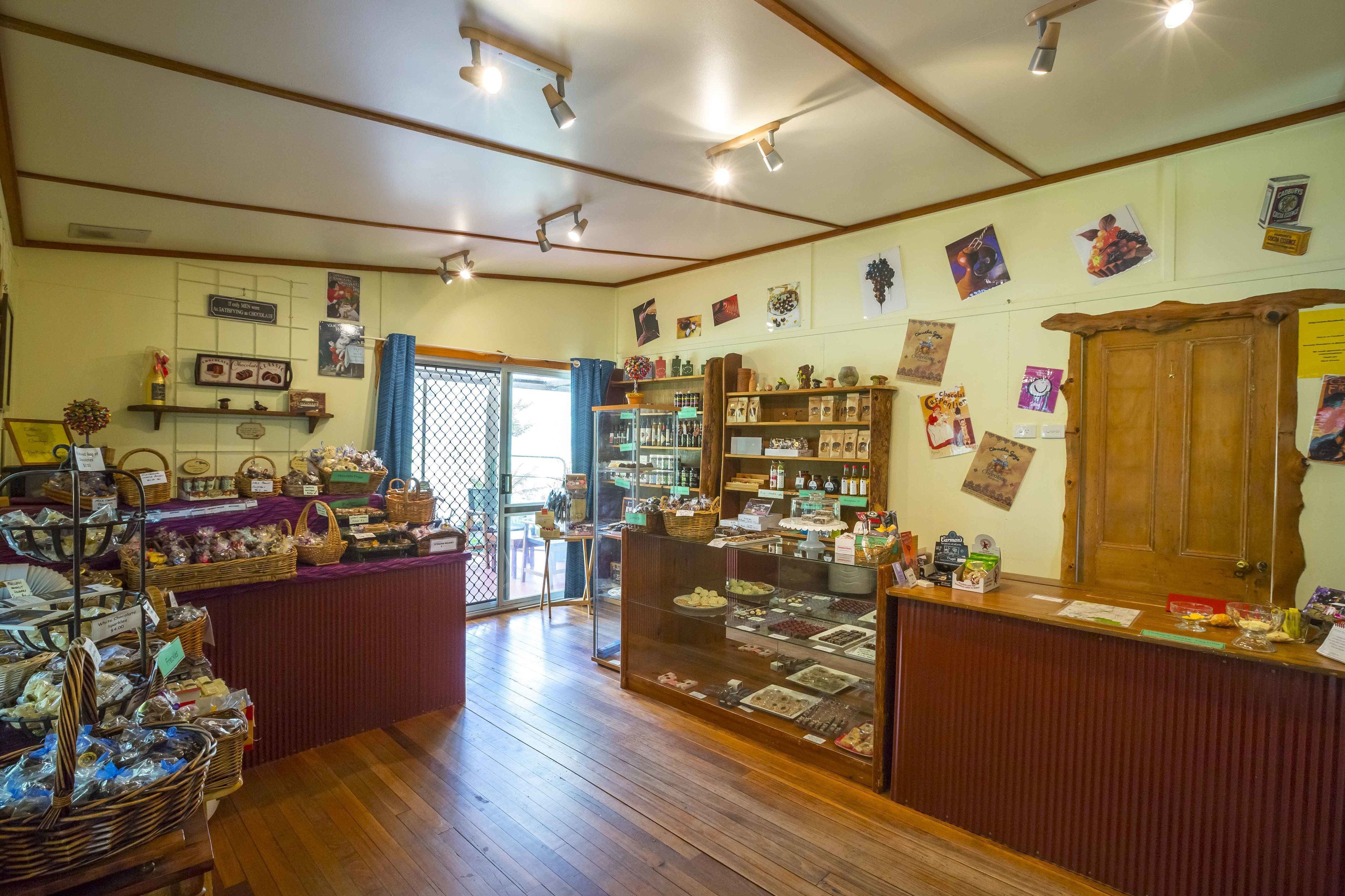 A bakery with wooden floors, display cases, and shelves with baked goods.