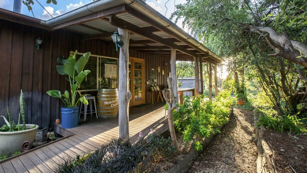 Eine Holzhütte mit überdachter Veranda, Topfpflanzen und einer Holzterrasse.