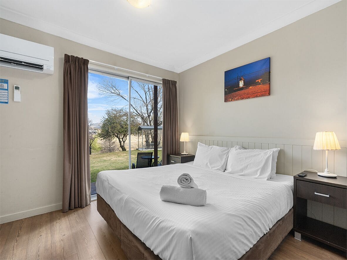 Una camera d'albergo con un letto grande, un quadro appeso e vista sull'esterno.
