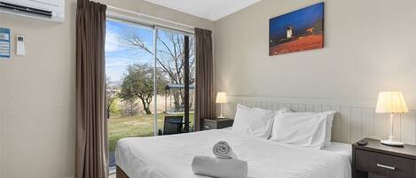 Una camera d'albergo con un letto grande, un quadro appeso e vista sull'esterno.