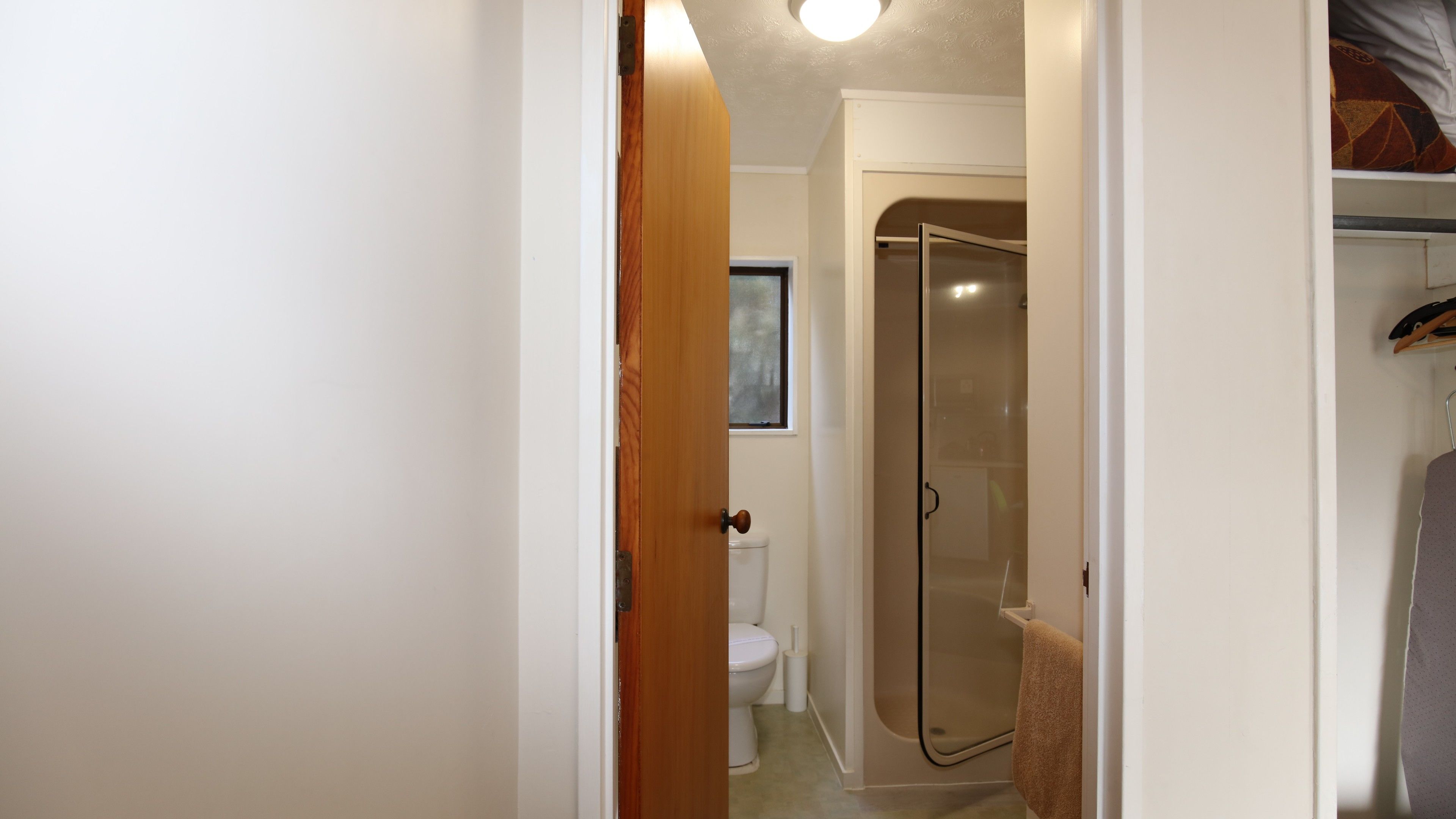 Une salle de bain équipée de toilettes, d’une douche et d’un porte-serviettes.