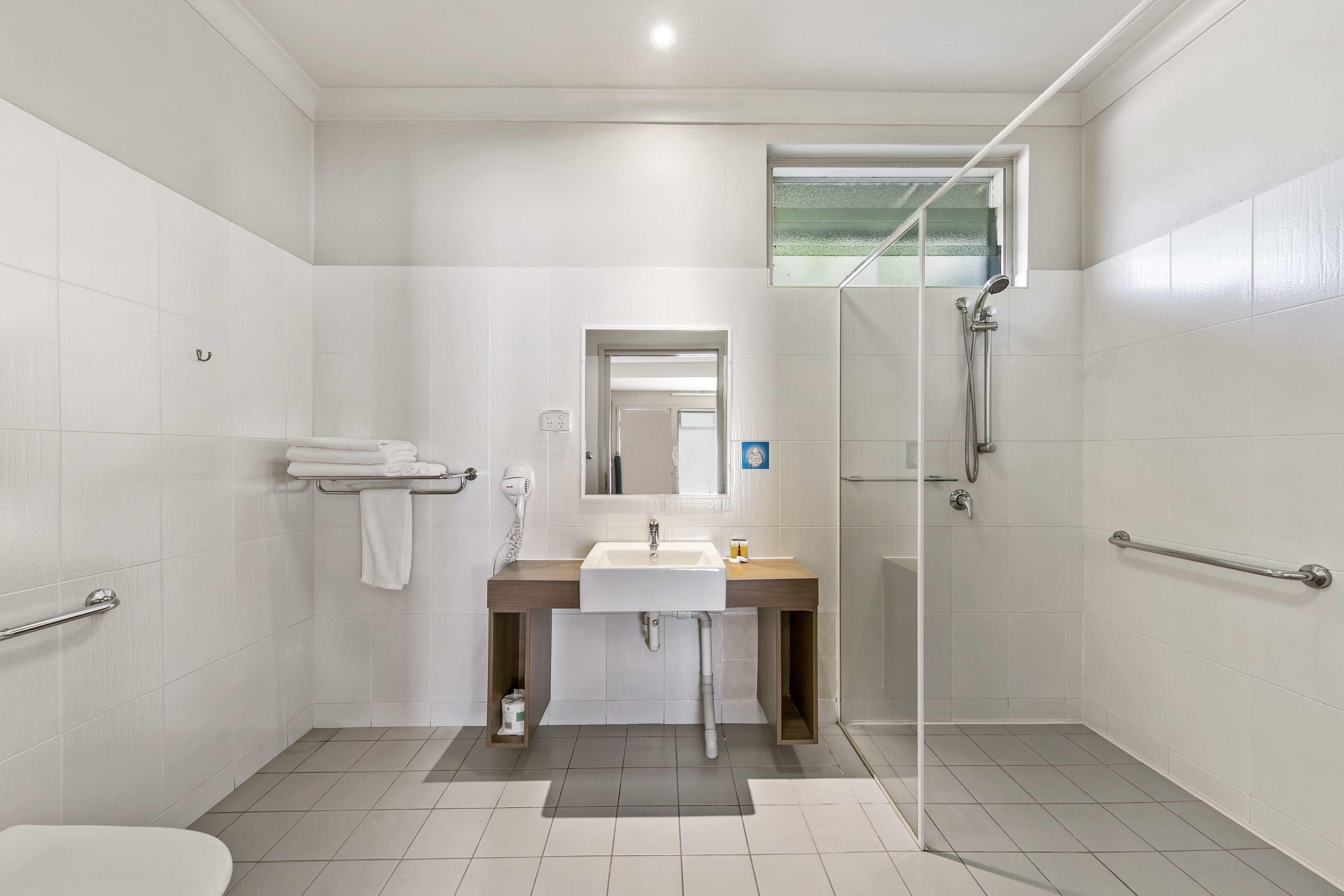 A modern bathroom with a shower, toilet, and sink.