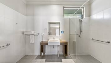 A modern bathroom with a shower, toilet, and sink.