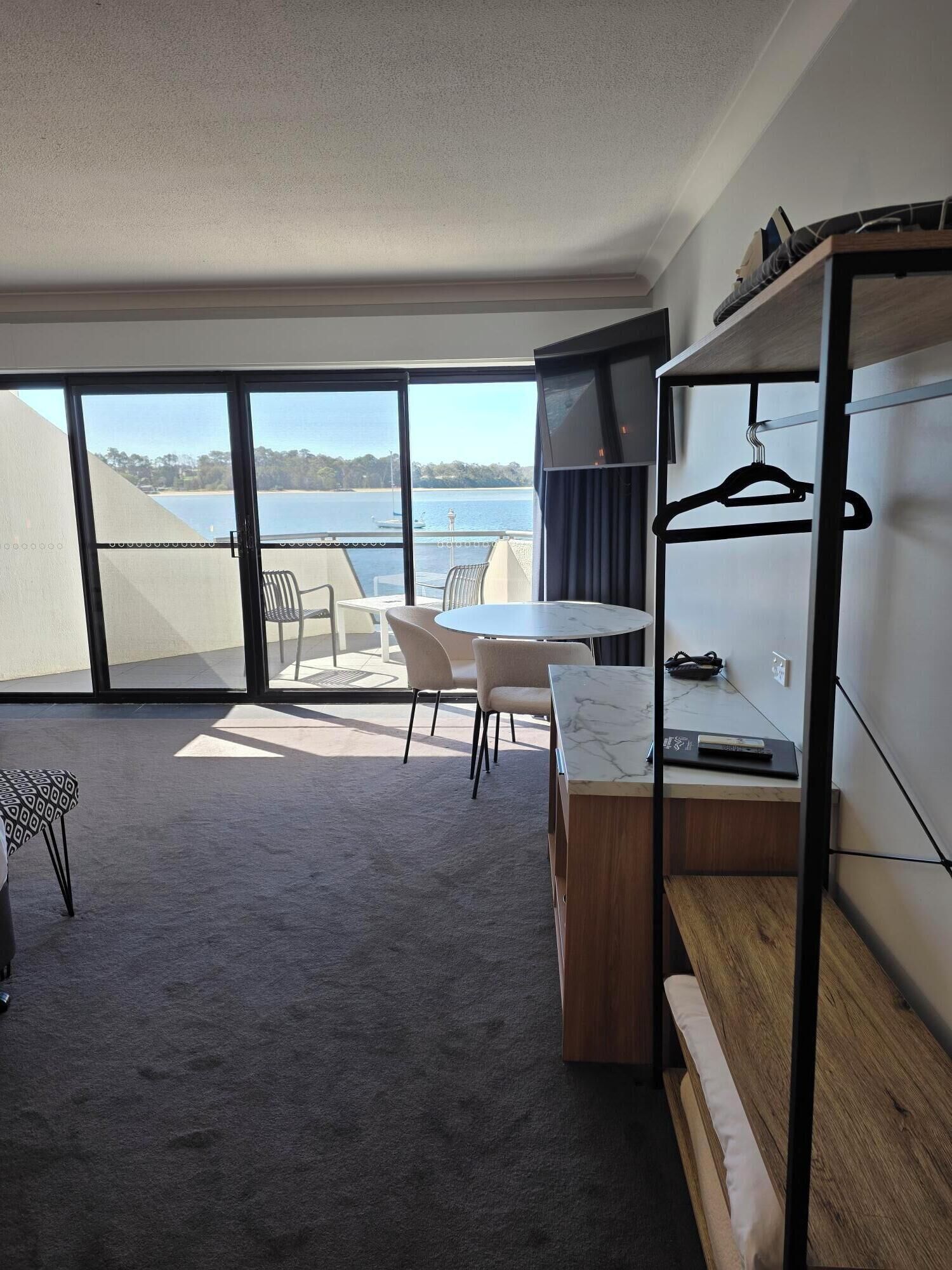 Una habitación de hotel moderna con balcón, zona de comedor y espacio de estar.
