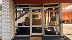A reception area with a 'Yes, We are Open' sign, a 'No Cash' policy, and a 'Keys' machine.