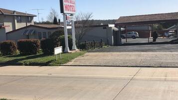 Un motel appelé « Anna Bella Motel », avec une enseigne, un parking et un bâtiment doté d’un toit en tuiles.