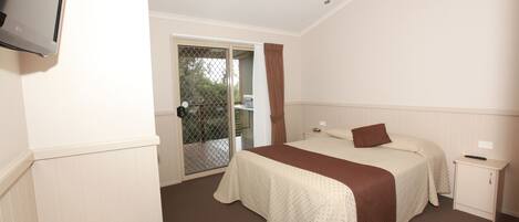 A bedroom with a bed, a nightstand, a ceiling fan, and a door leading to an outdoor area.