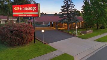An EconoLodge sign, a parking lot, and a building with a red roof.