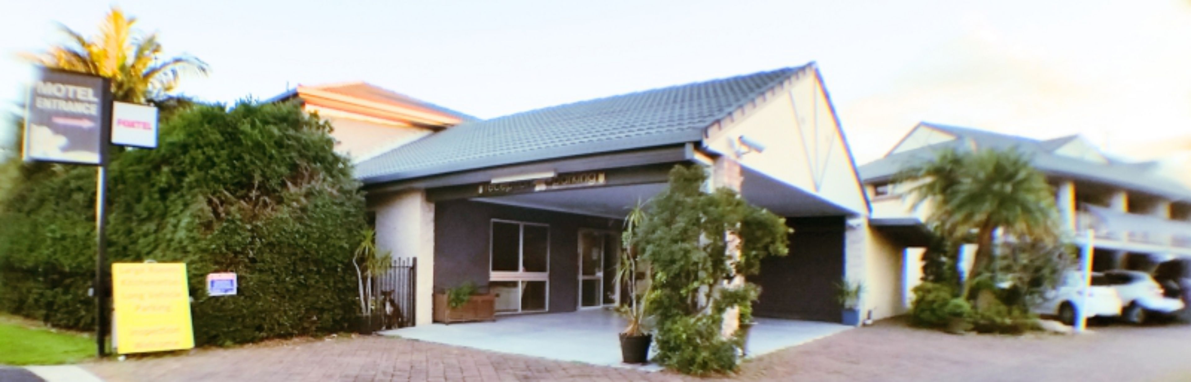 Un motel doté d’une entrée abritée, d’une enseigne et d’un espace de stationnement.