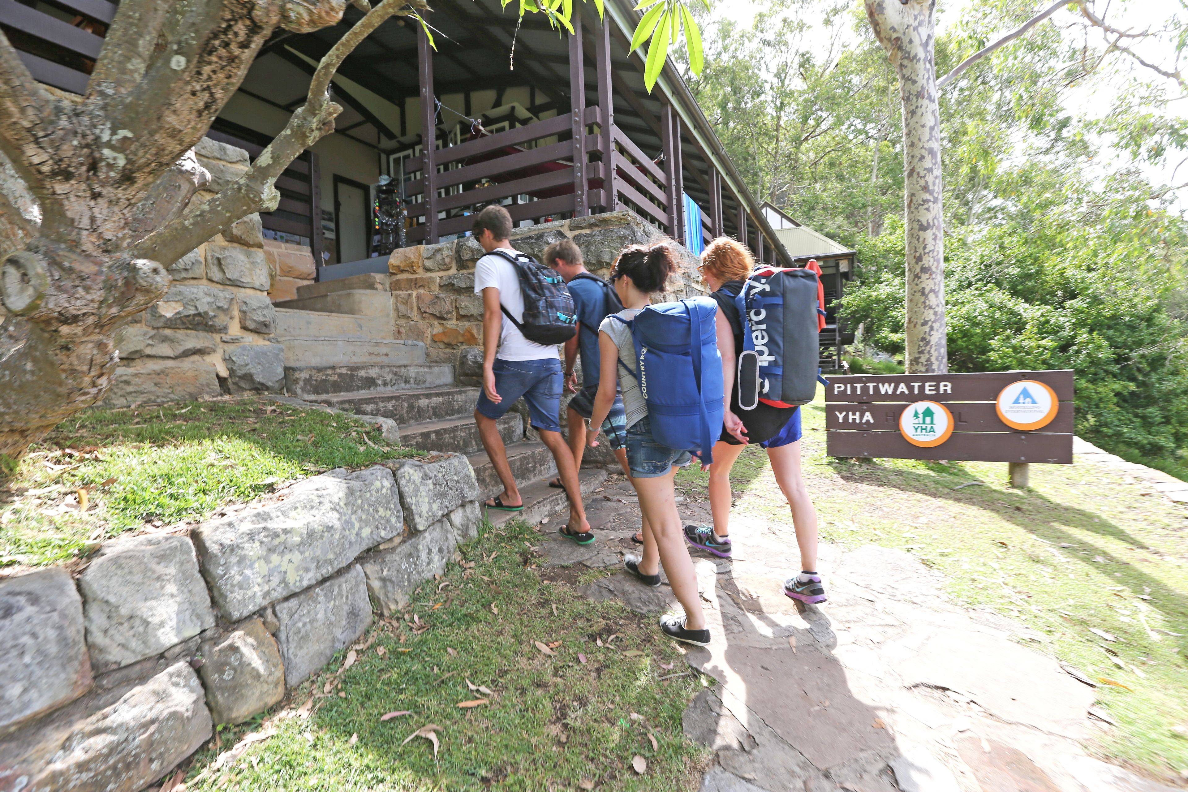 A group of people approaching a stone staircase leading to a wooden structure.