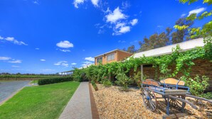 A house with a stone wall and a wooden fence. - Moama Central Motel (Moama)