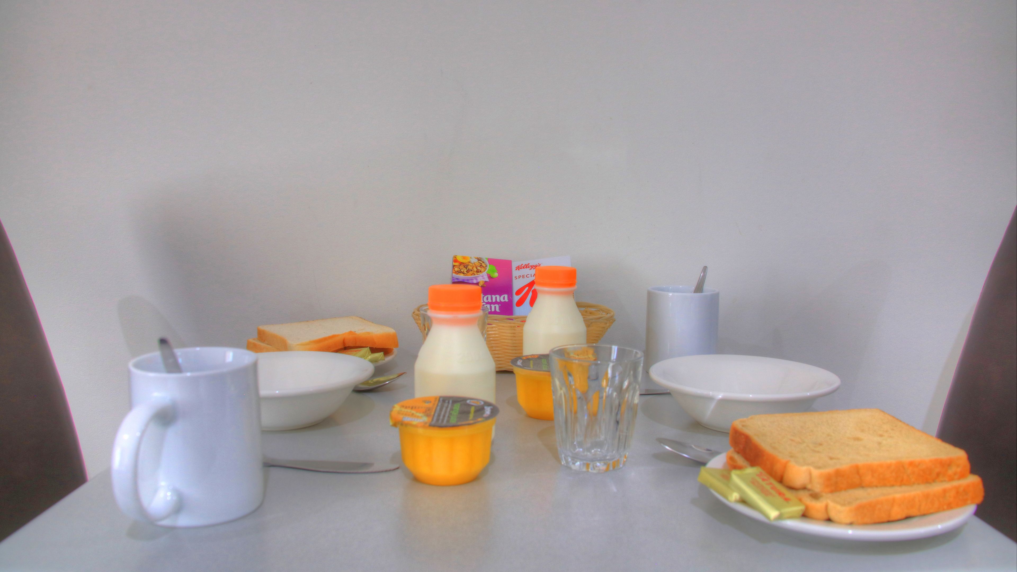 A breakfast setup with bread, milk, and cereal.