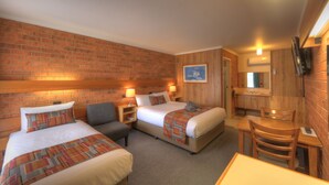 A hotel room with two beds, a desk, a chair, a bathroom, and a TV on the wall. - Moama Central Motel (Moama)