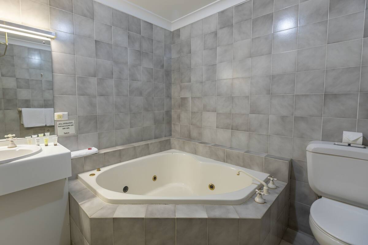 A modern bathroom with a freestanding bathtub, a double sink vanity, and a toilet.