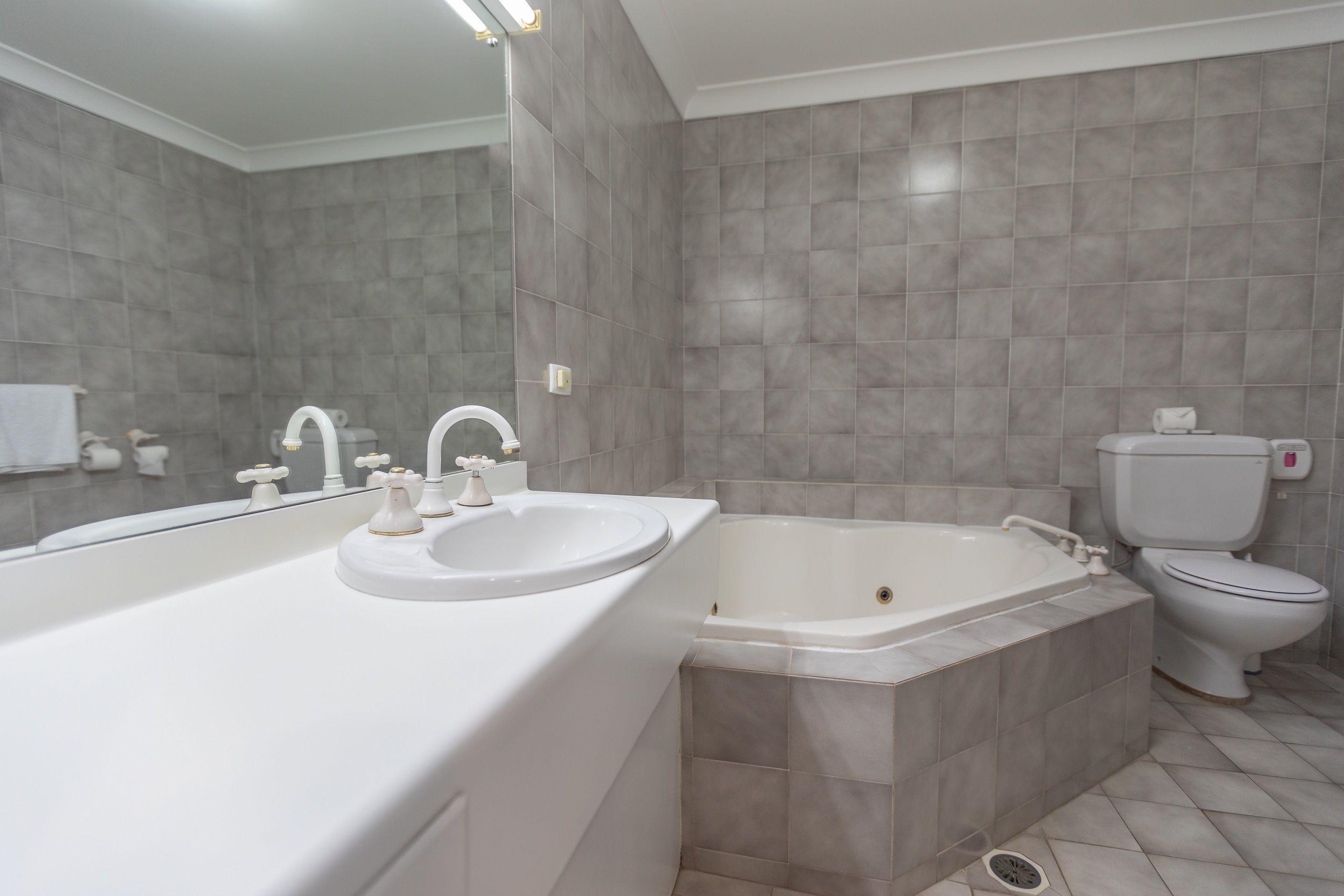 A modern bathroom with a large bathtub, a sink, and a toilet.