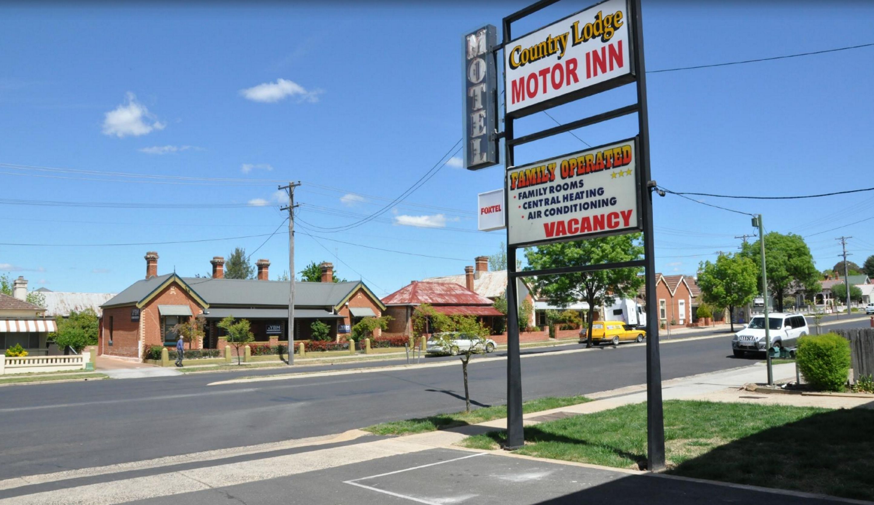 Un letrero de motel con aviso de habitaciones disponibles.