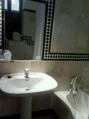 A bathroom with a sink, a mirror, and a bathtub. - Hotel Balneario Sierra Alhamilla (Pechina)