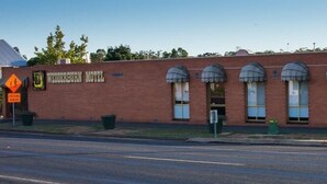 Un edificio in mattoni con finestre ad arco e un cartello con la scritta 'Weddersburn Motel'.