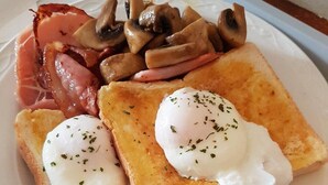 Un piatto con pane tostato, uova in camicia e funghi a fette.