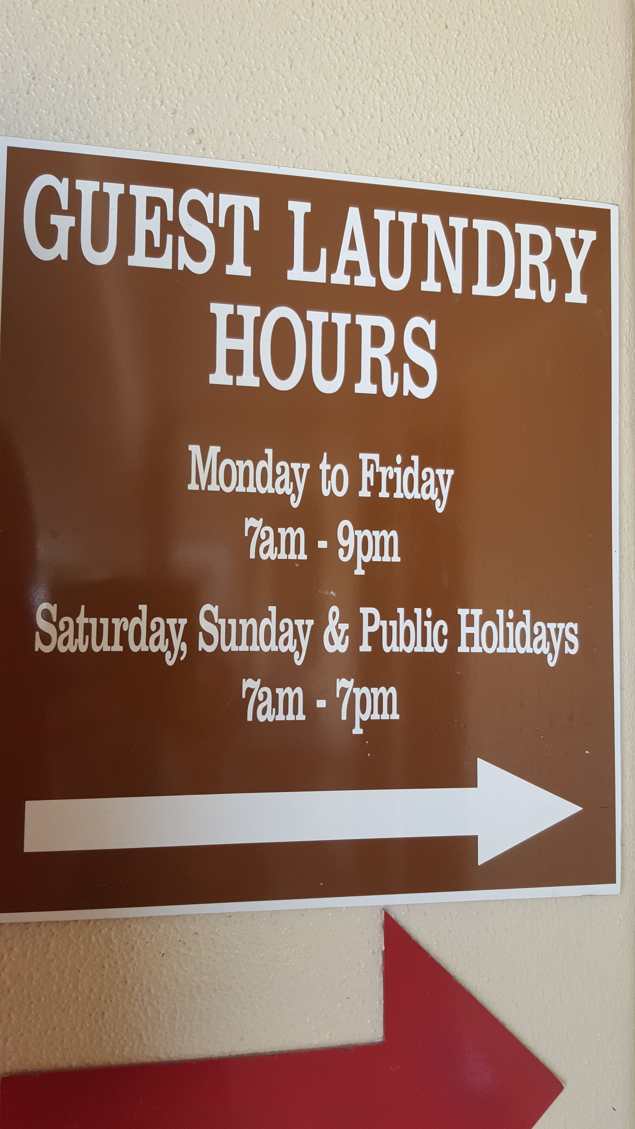 A sign indicating guest laundry hours at a hotel.