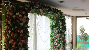 A room with a floral archway, white curtains, and a green carpet. - Glenmore Palms Motel (Norman Gardens)