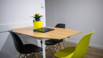 A conference room with a wooden table, black and yellow chairs, and a potted plant on the table.