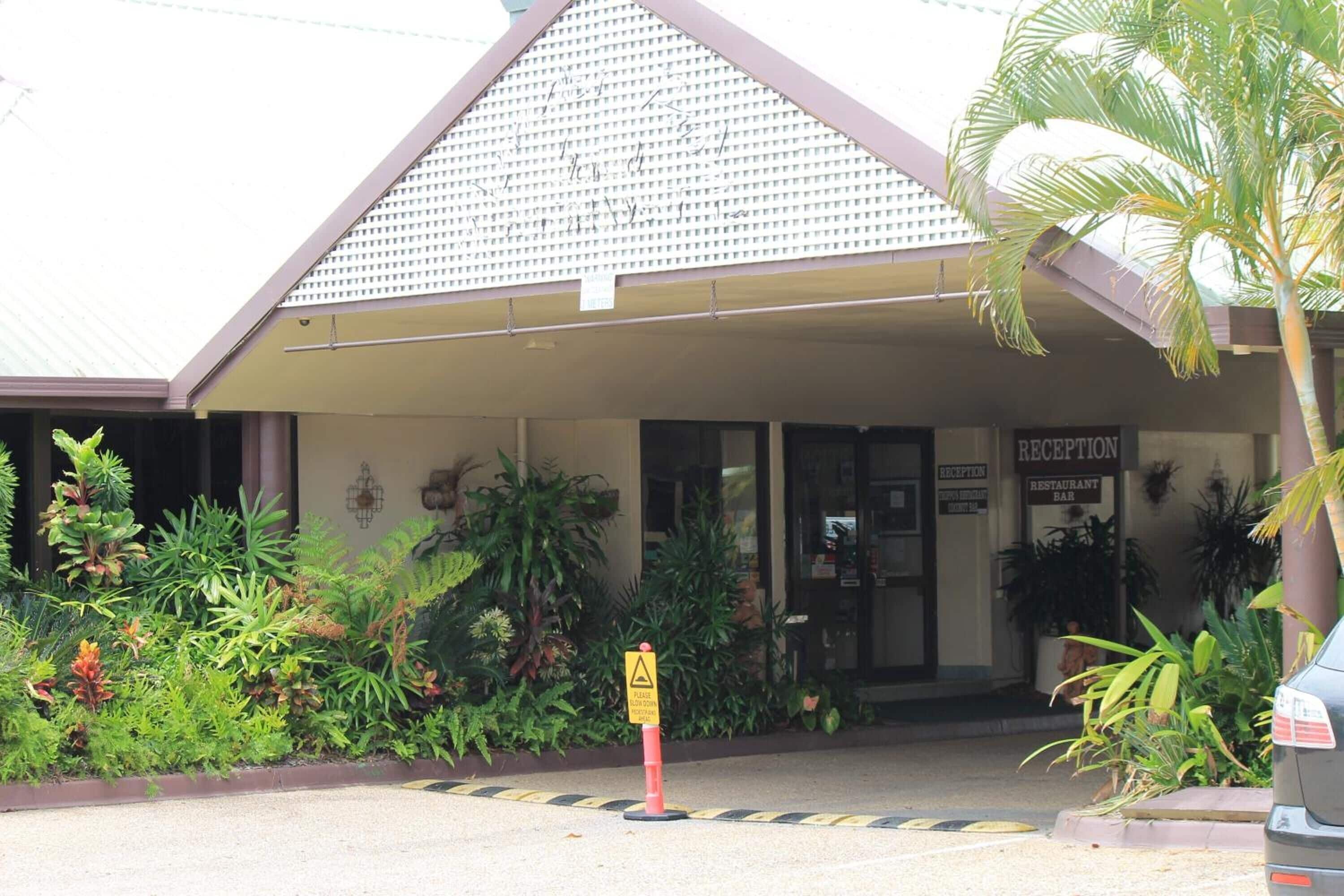 A building with a reception area, a sign indicating a restaurant bar, and a yellow caution sign.