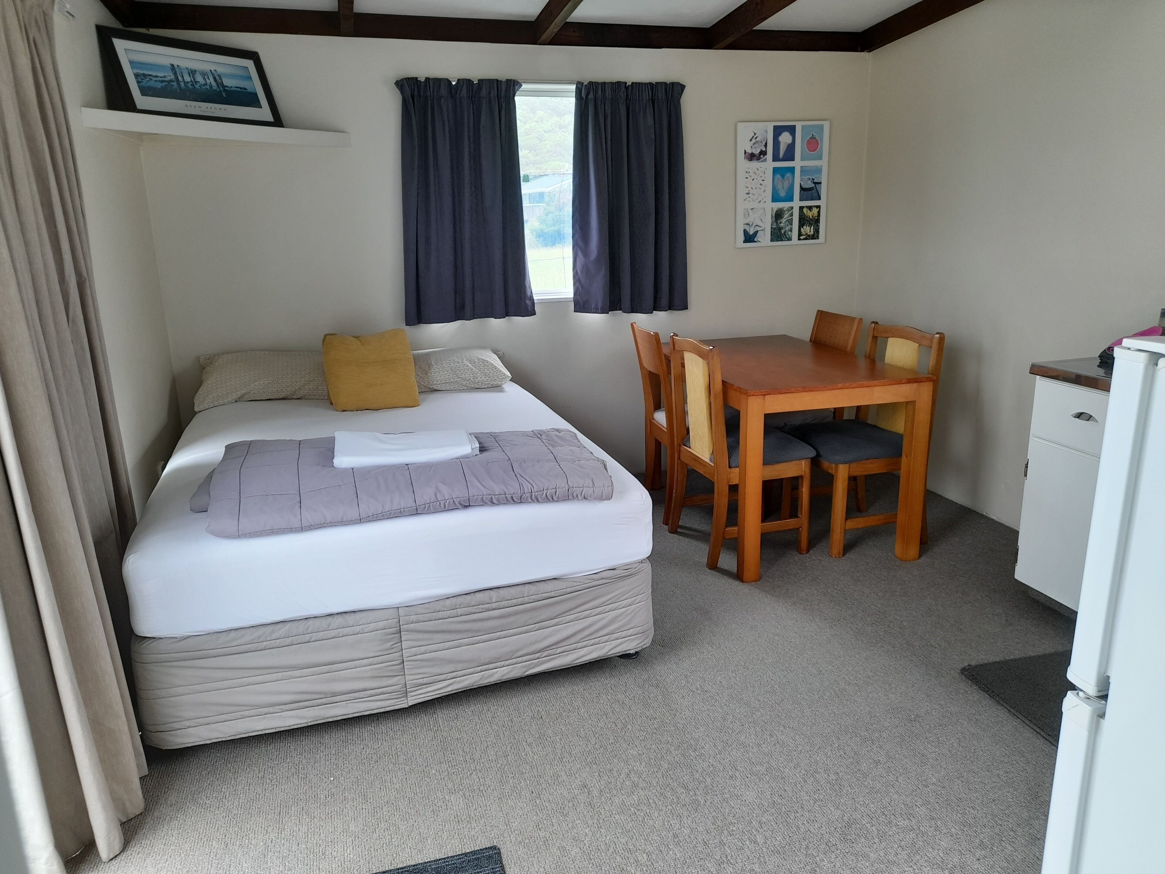 A bedroom with a bed, a desk, and a chair.