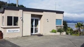 Edificio de recepción con un cartel que dice "Reception", ventanas amplias y vistas al mar.