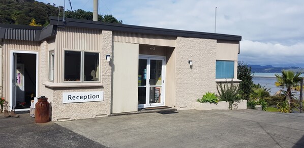 A reception building with a sign labeled "Reception," large windows, and a view of the sea.
