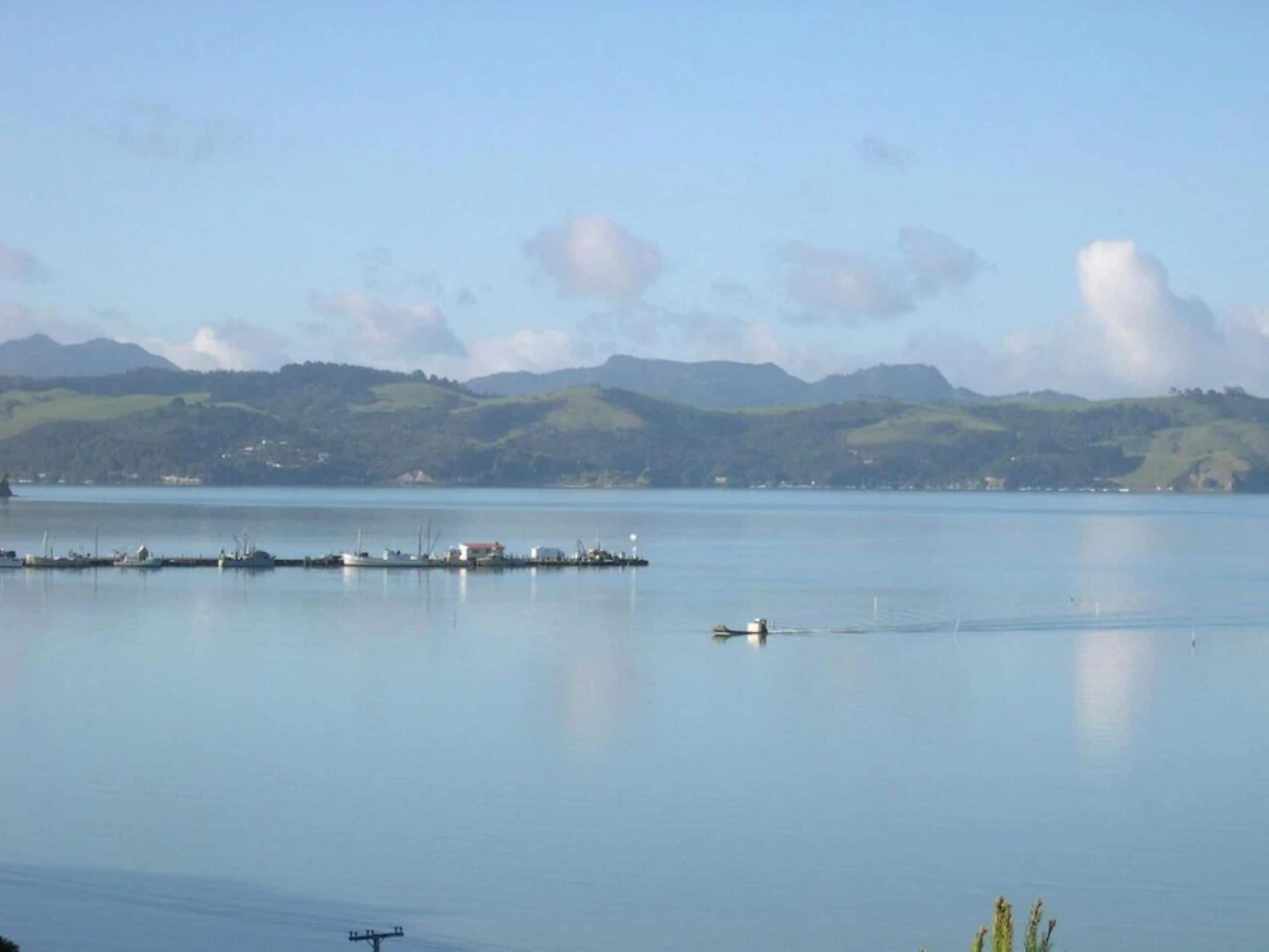 A calm lake with a dock and a small boat.