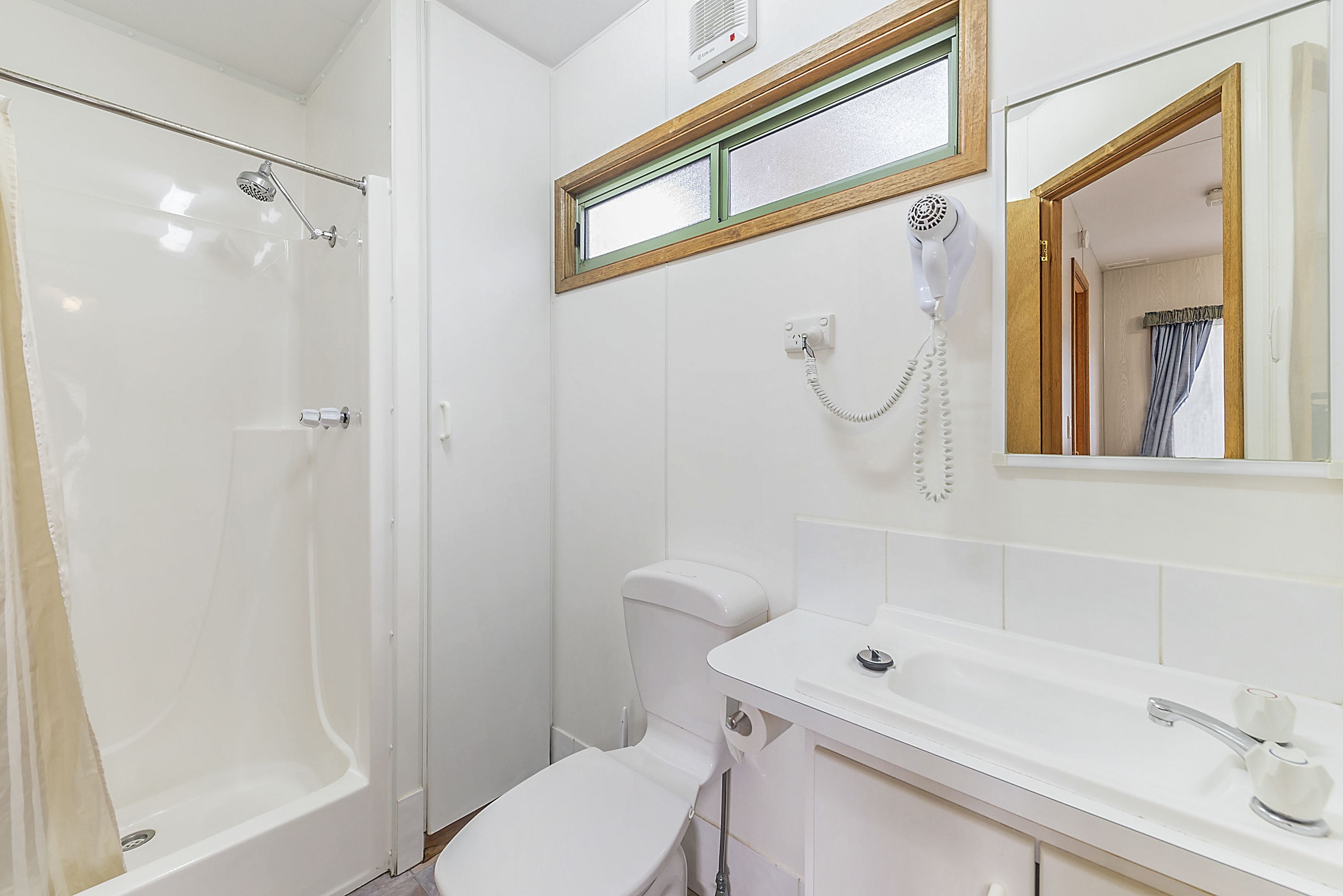 A bathroom with a shower, toilet, and sink.