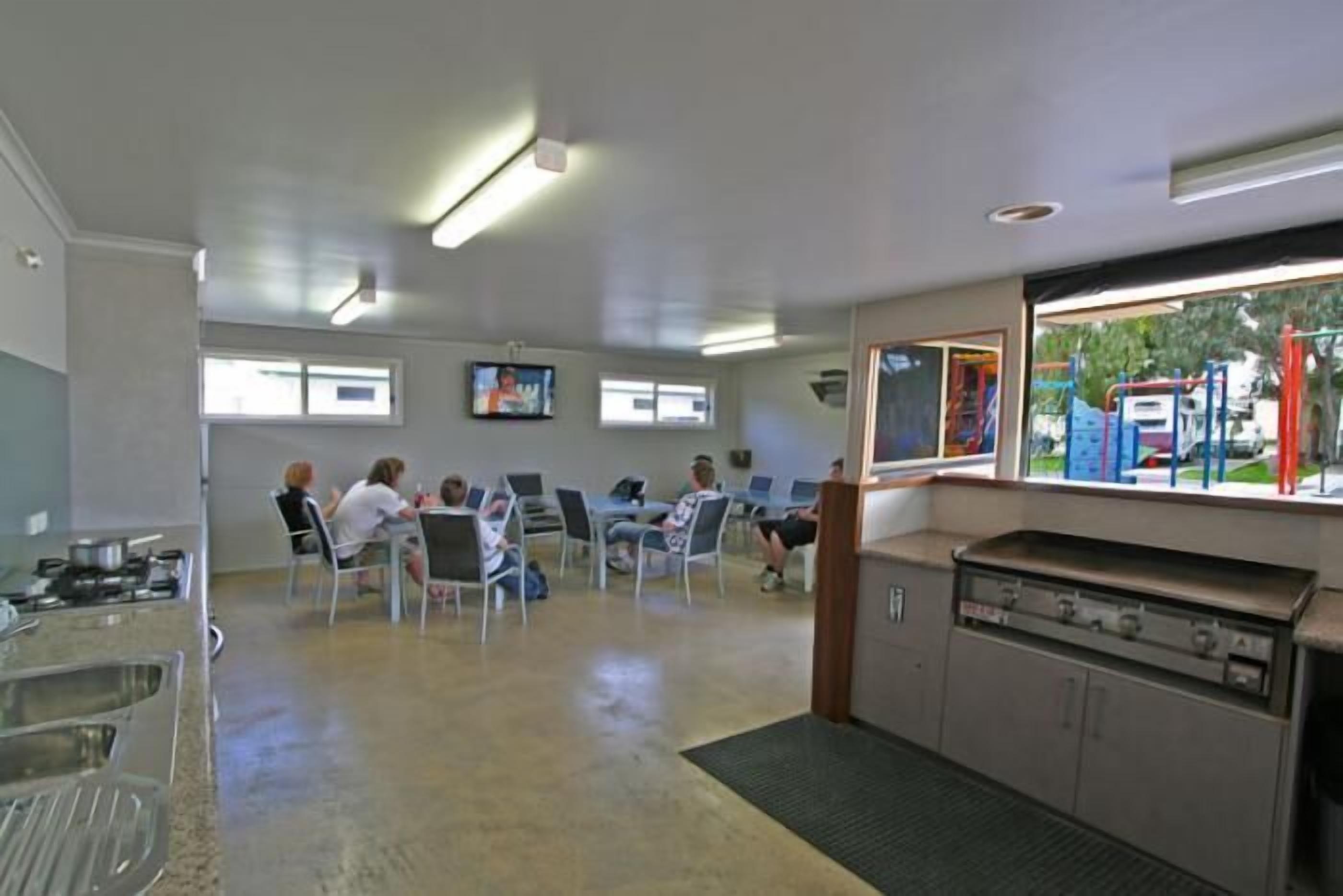 A dining area with a counter, chairs, and a grill station.