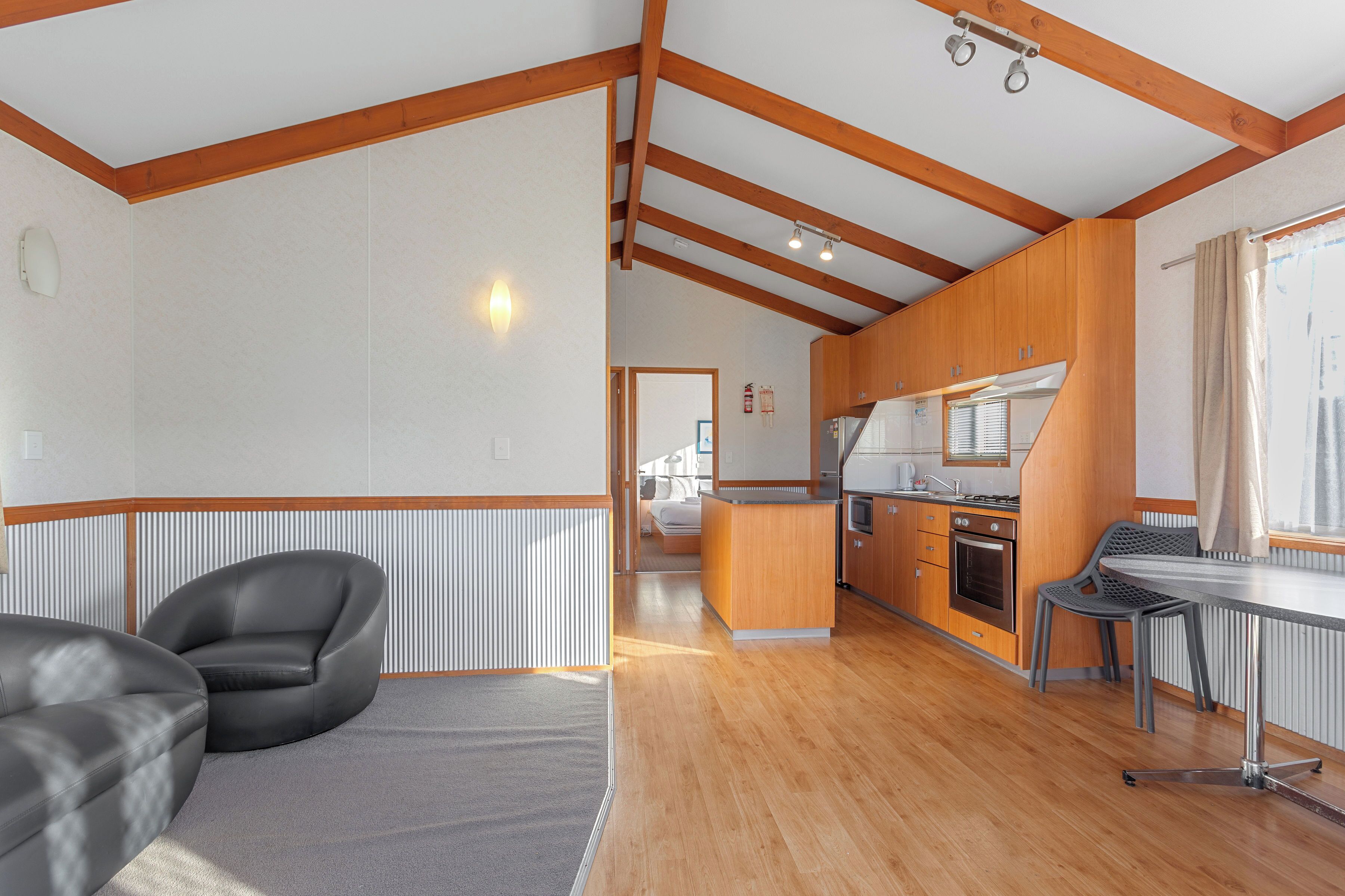 Un salón amplio con un sofá, una mesa de comedor y una cocina al fondo.
