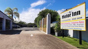 A Motor Inn sign with amenities including free WiFi, Foxtel, sport & movie, BBQ, breakfast, and parking for trailers and trucks.