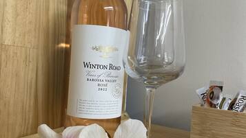 Eine Flasche Winton Road Wein, ein Glas und eine Holzkiste mit Packungen auf einer Holztischplatte.