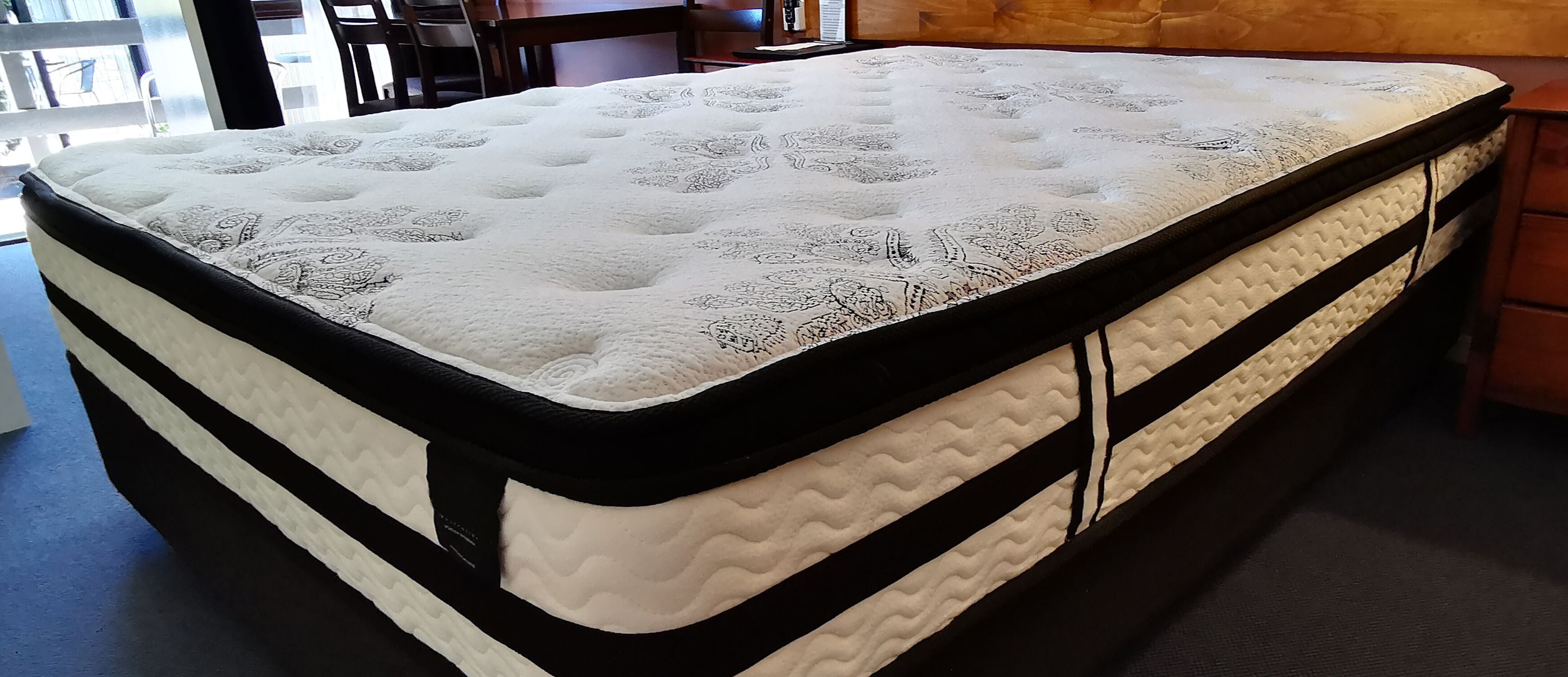 A mattress with a patterned top and black and white sides.